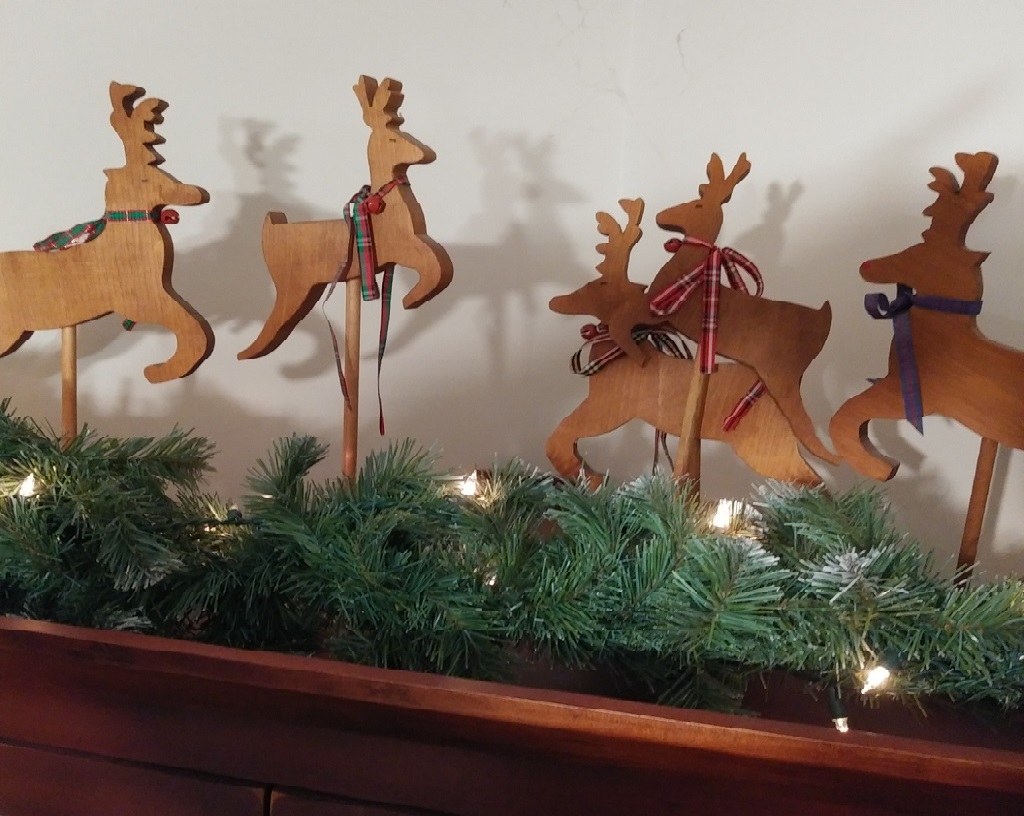 A picture of five wooden Christmas reindeer with their shadows reflecting on a wall to reflect on the real you. 